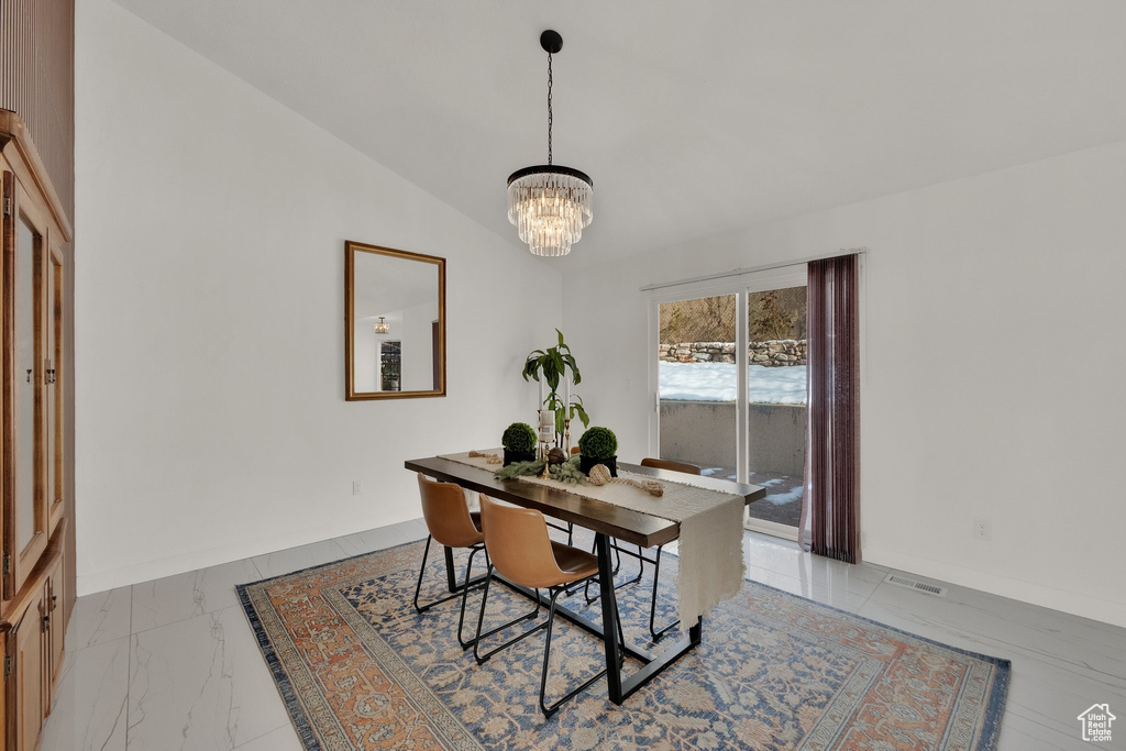 Dining room featuring vaulted ceiling and an inviting chandelier