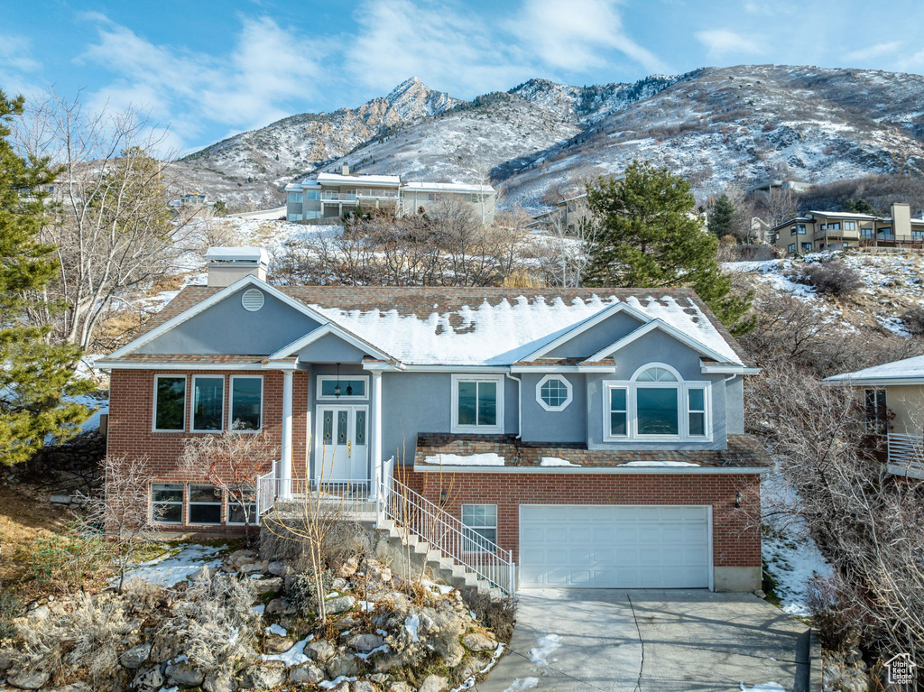 View of front of property with a mountain view and a garage