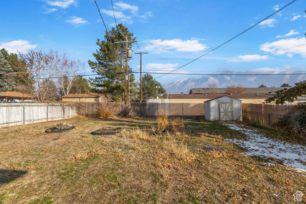 View of yard featuring a mountain view and a storage unit