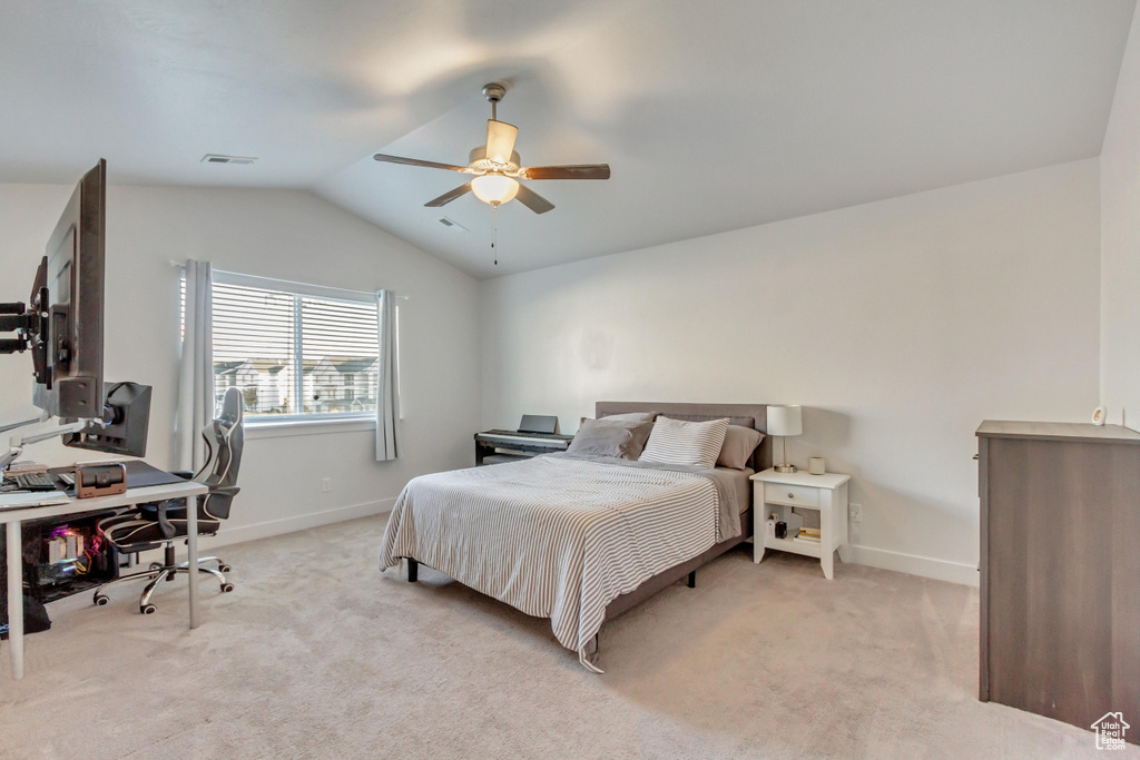 Bedroom featuring ceiling fan, light carpet, and vaulted ceiling