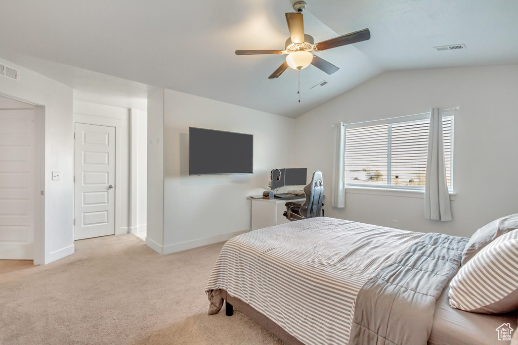 Bedroom with ceiling fan, lofted ceiling, and light carpet