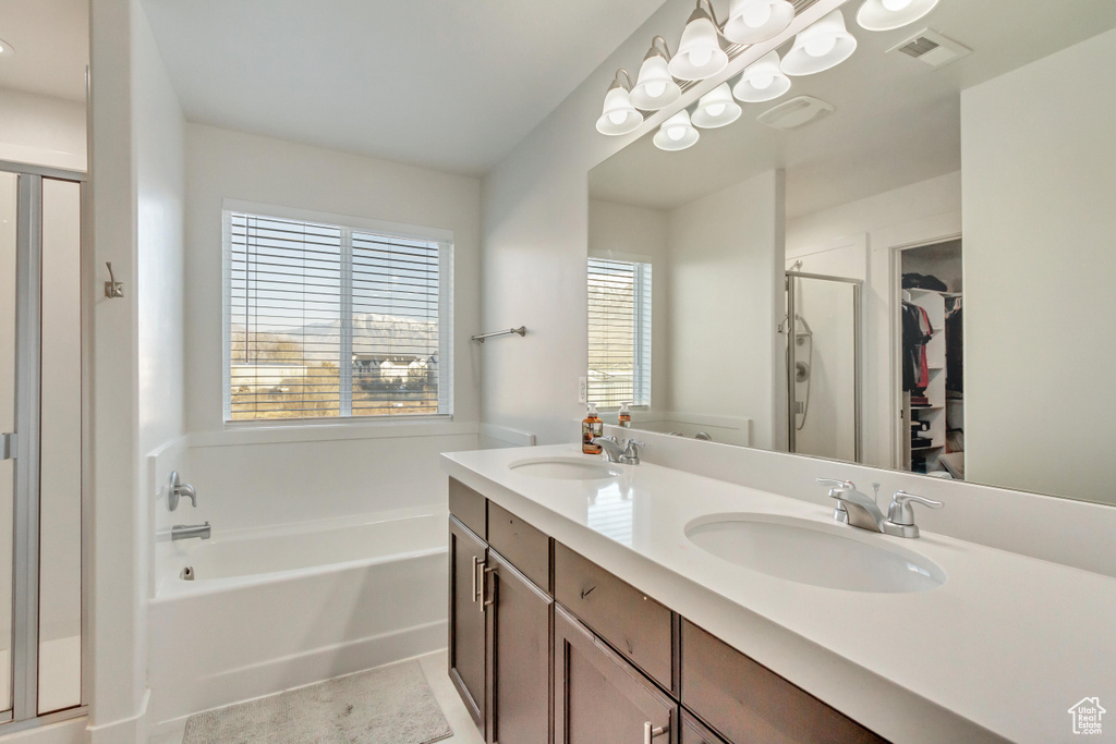 Bathroom with tile patterned floors, plus walk in shower, and vanity