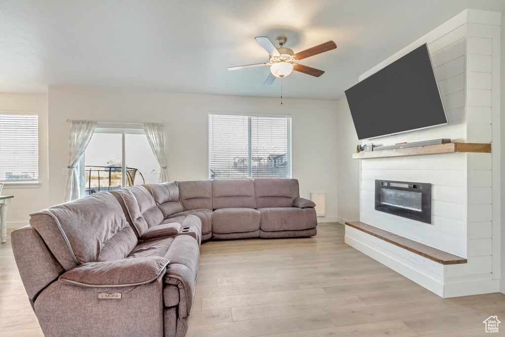 Living room featuring light wood-type flooring and ceiling fan