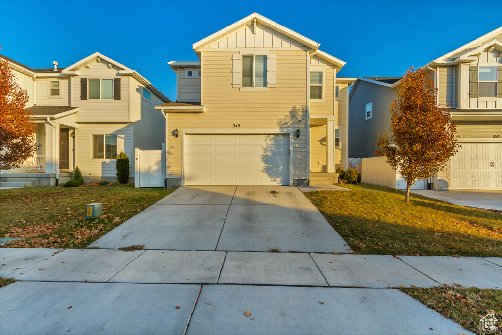 View of front facade featuring a garage and a front lawn