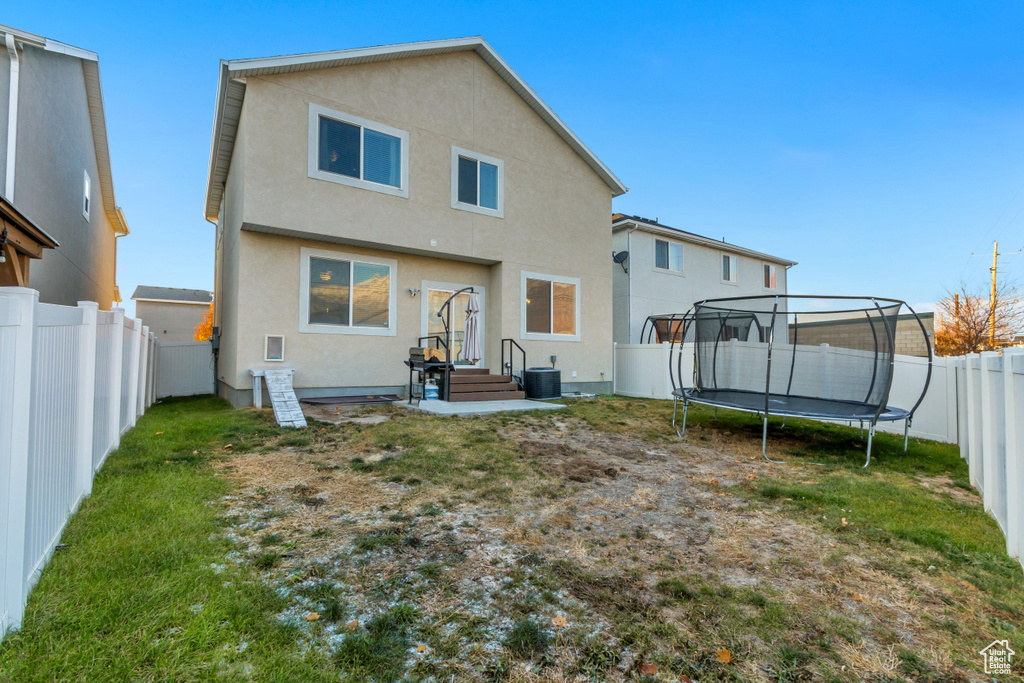 Back of property featuring a trampoline