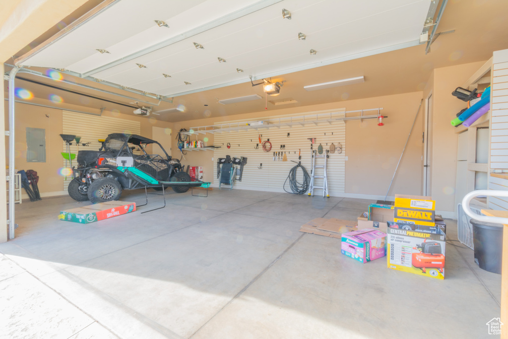 Garage featuring electric panel and a garage door opener