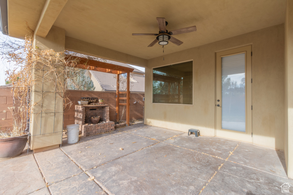 View of patio / terrace featuring an outdoor brick fireplace and ceiling fan