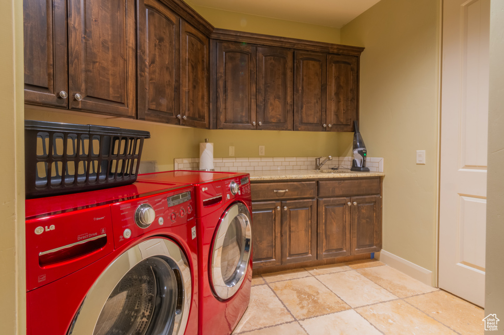 Laundry room featuring cabinets and separate washer and dryer