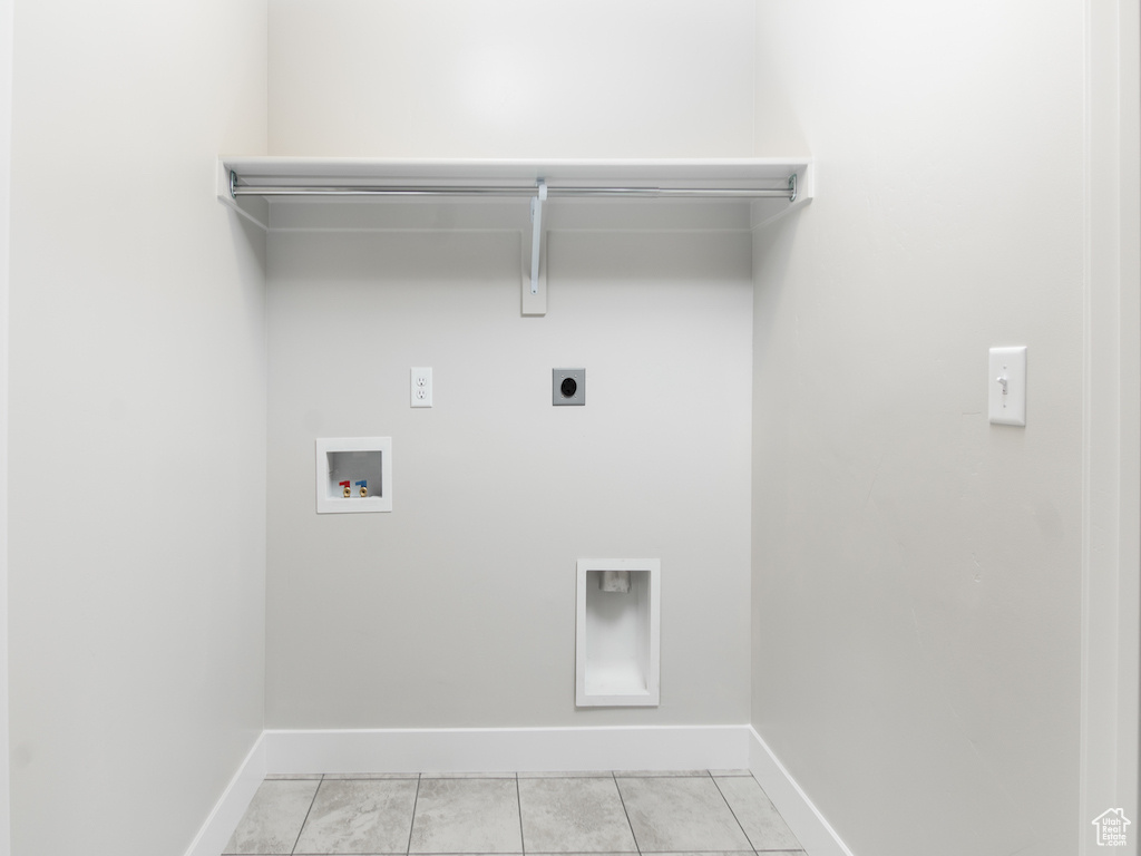 Laundry area featuring hookup for an electric dryer, washer hookup, and light tile patterned flooring