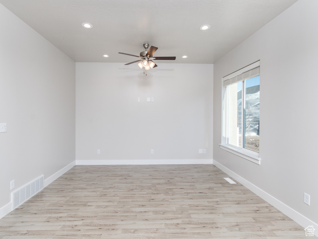 Spare room with ceiling fan and light wood-type flooring