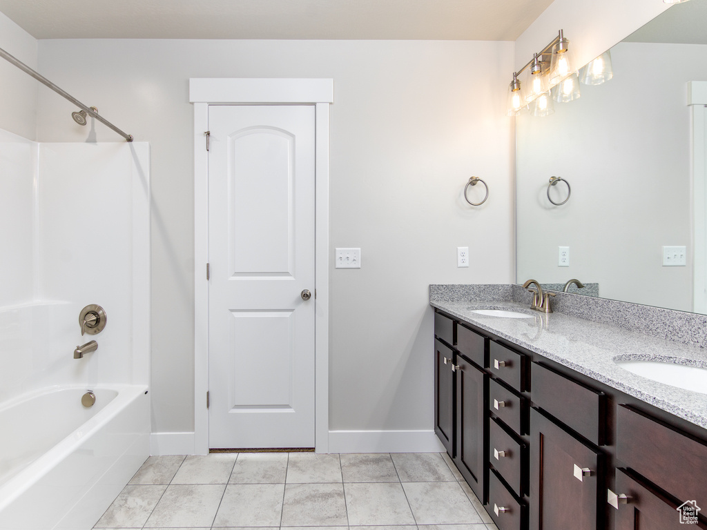 Bathroom with vanity, shower / tub combination, and tile patterned floors