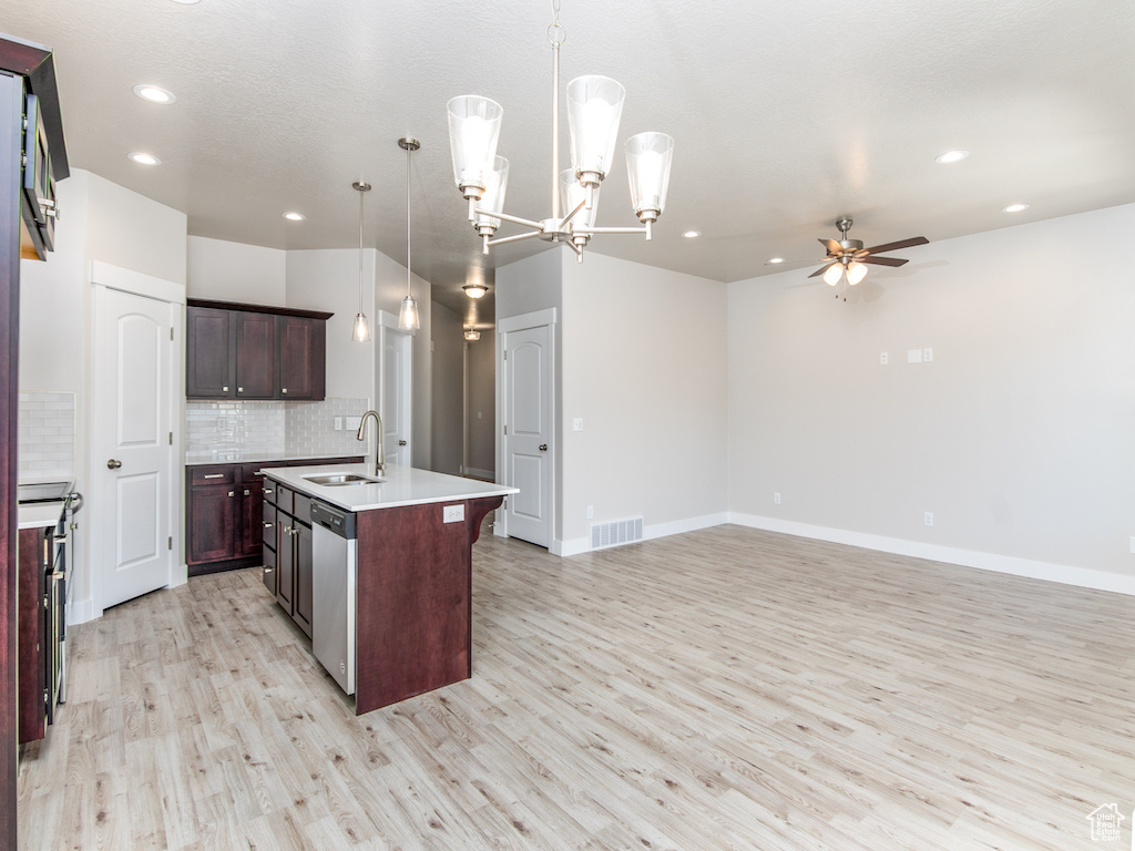 Kitchen with light hardwood / wood-style floors, dishwasher, an island with sink, backsplash, and pendant lighting