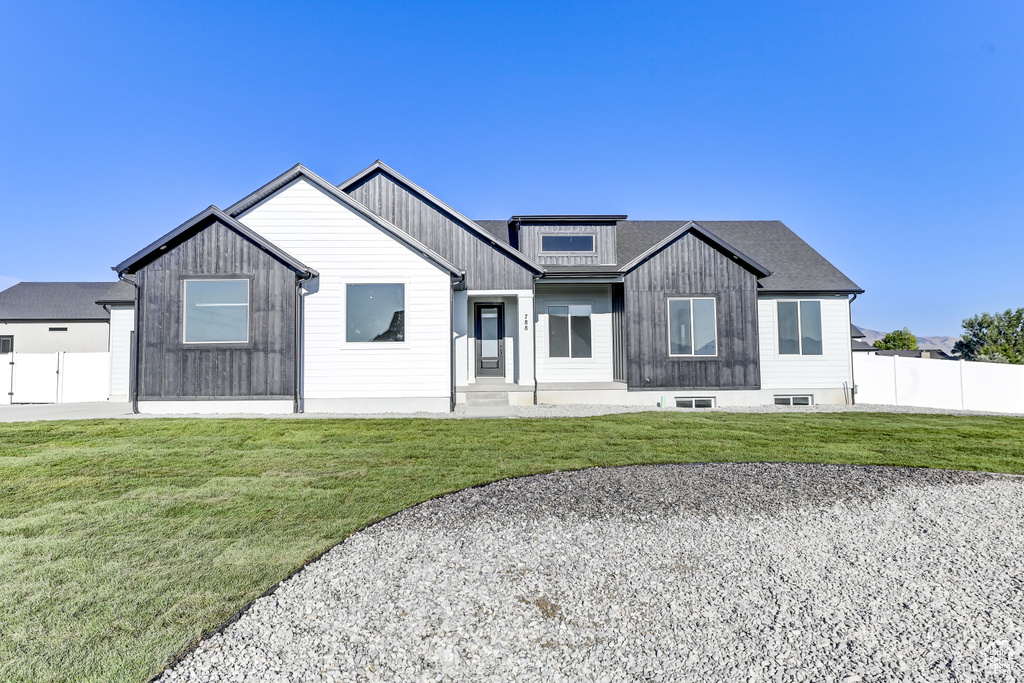 Modern farmhouse style home with a front yard