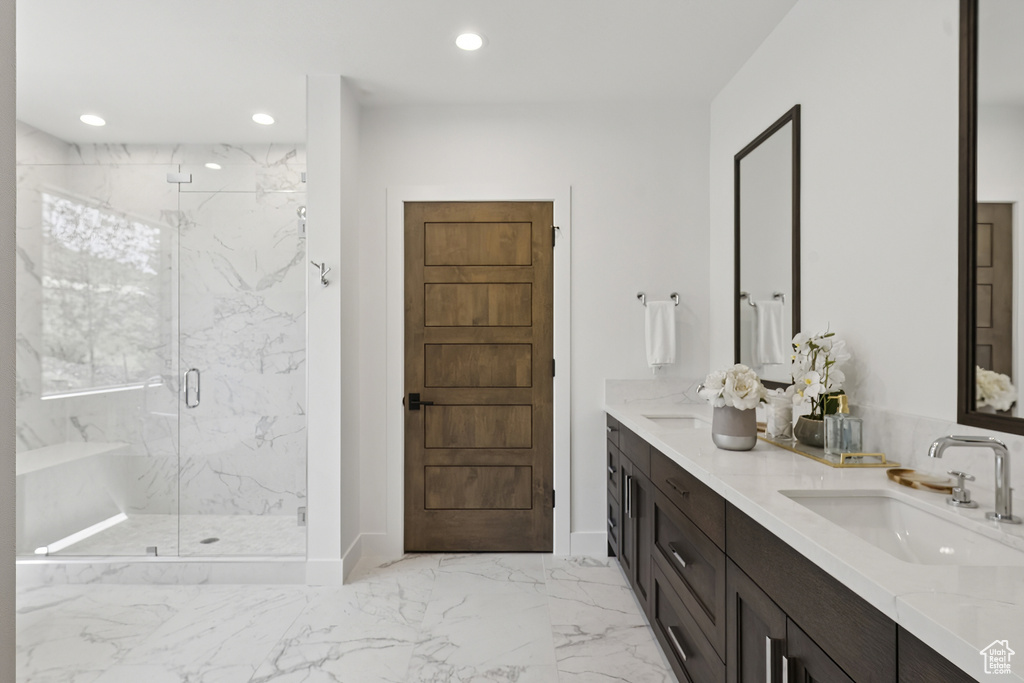Bathroom featuring double vanity, marble finish flooring, a marble finish shower, and recessed lighting