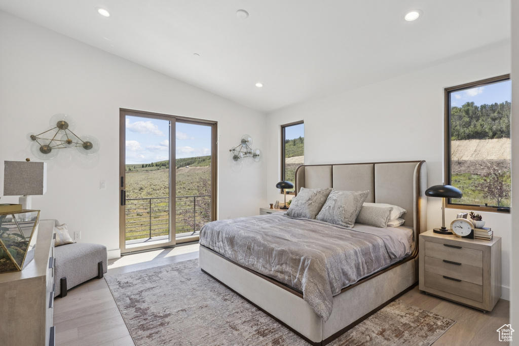 Bedroom with vaulted ceiling, access to outside, recessed lighting, and light wood finished floors