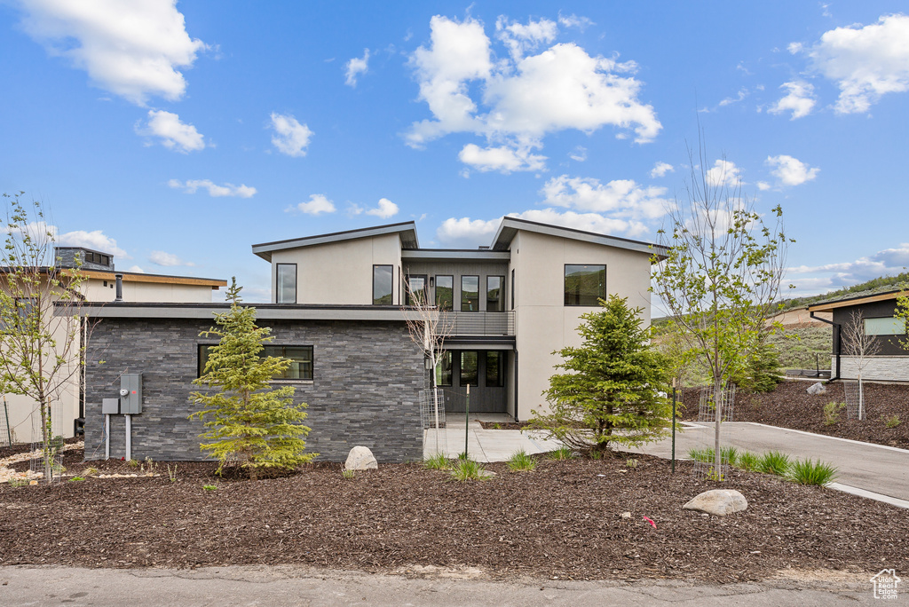 View of front facade with stucco siding and stone siding