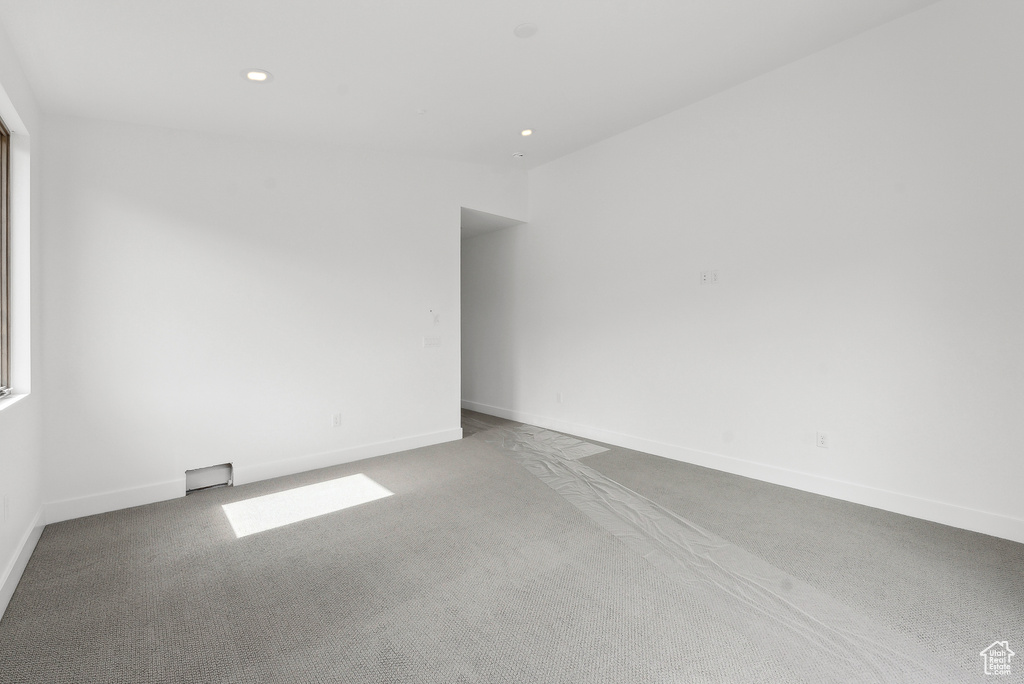 Carpeted spare room featuring baseboards and recessed lighting