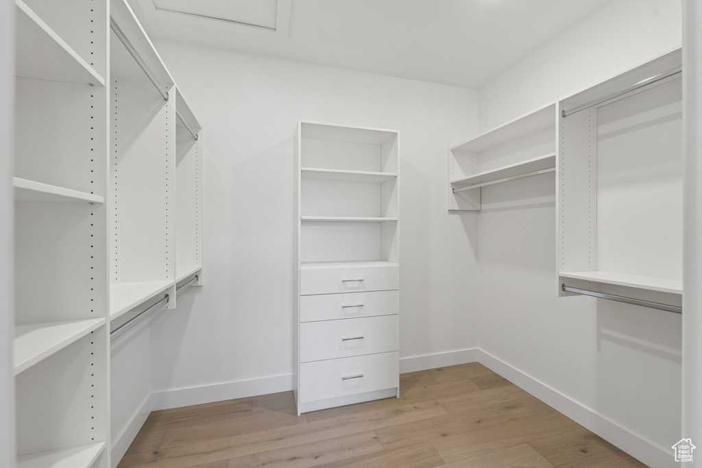 Spacious closet with light wood finished floors