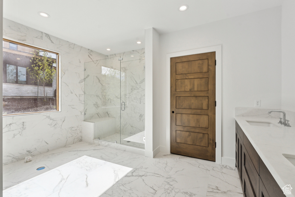 Full bath with recessed lighting, marble tiled flooring, a marble finish shower, and double vanity