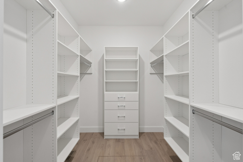 Walk in closet with light wood-type flooring