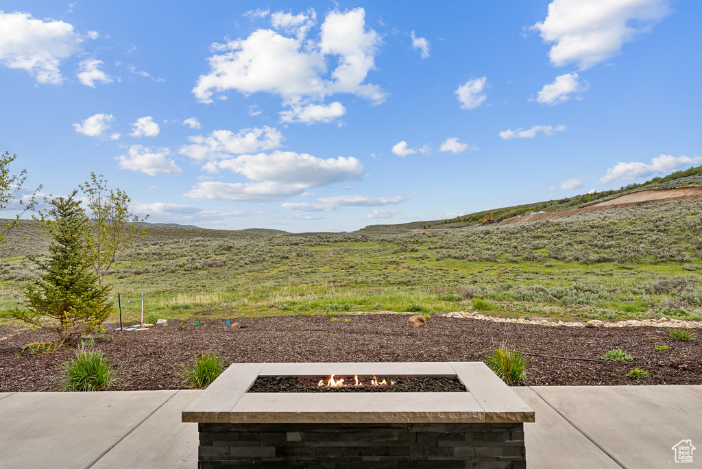 View of yard with an outdoor fire pit and a patio area