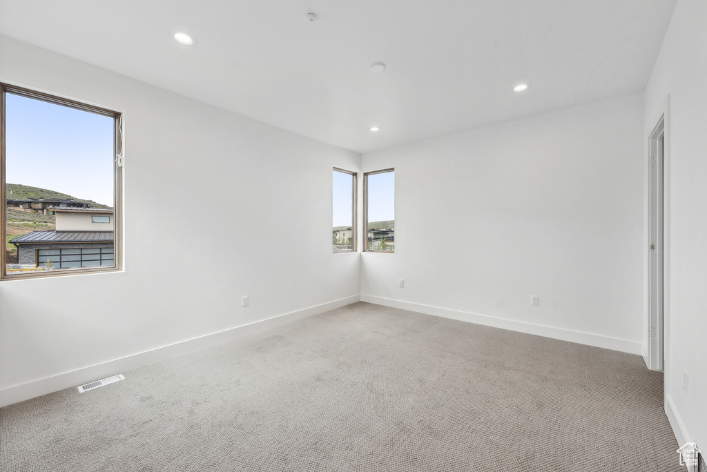 Carpeted spare room featuring recessed lighting and baseboards