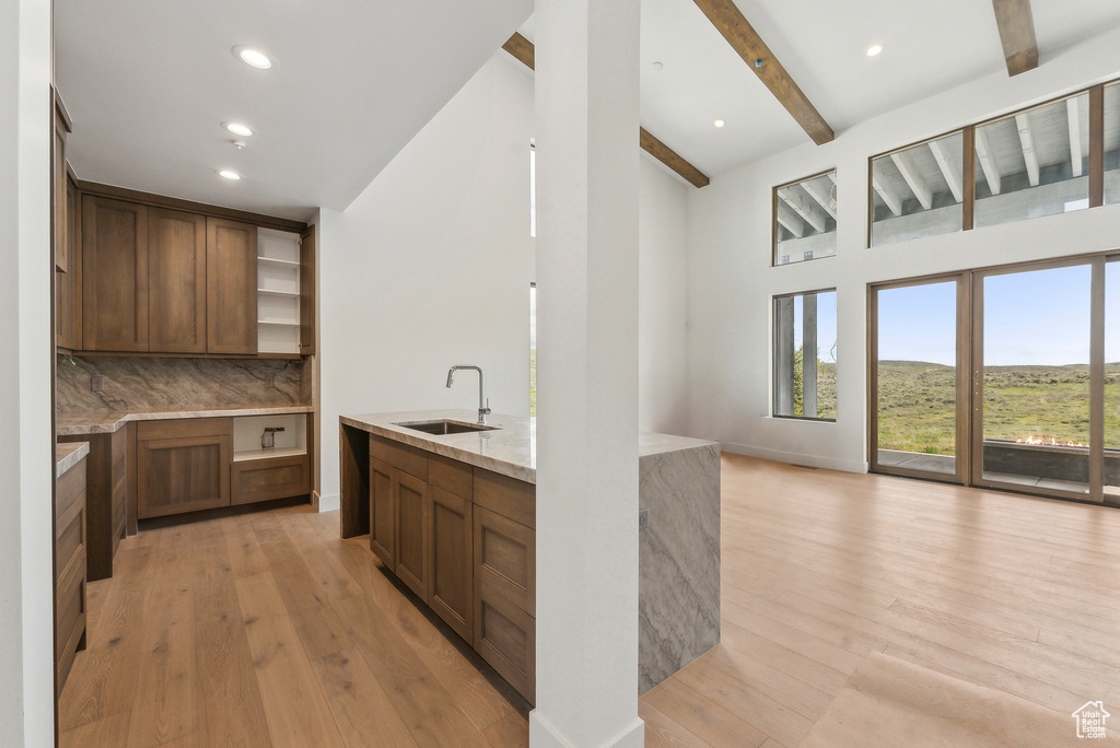 Kitchen featuring a sink, open shelves, plenty of natural light, light wood finished floors, and recessed lighting