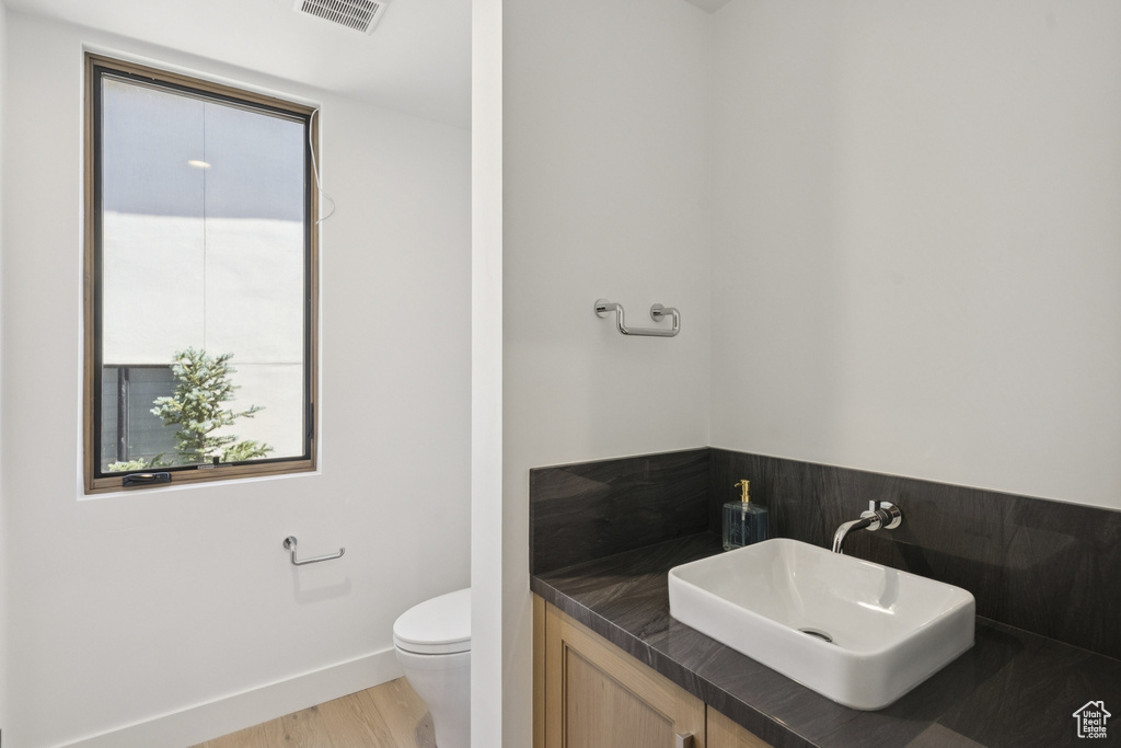 Half bathroom featuring vanity and wood finished floors