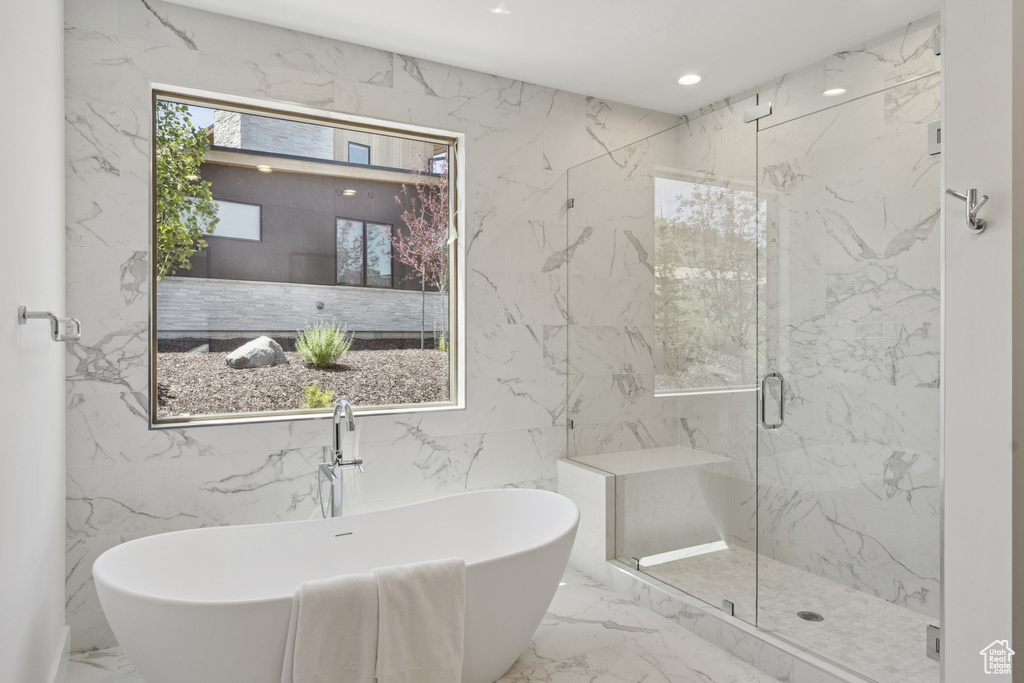 Full bath with marble tiled flooring, a marble finish shower, a soaking tub, and recessed lighting