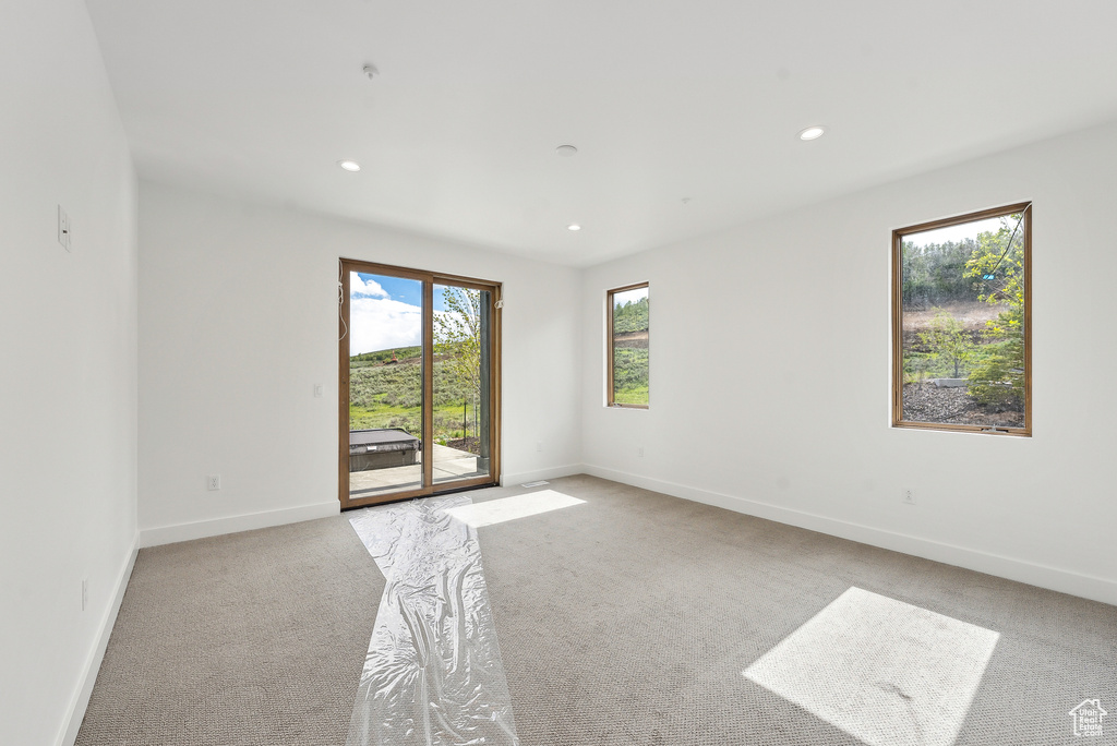 Empty room featuring light carpet, recessed lighting, and baseboards