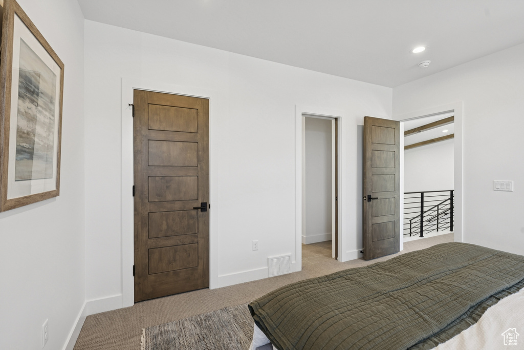 Carpeted bedroom with a spacious closet and recessed lighting