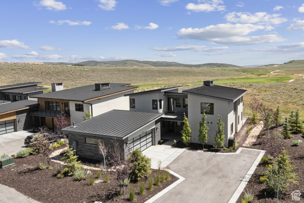 View of front of home featuring a metal roof, driveway, a mountain view, and a standing seam roof