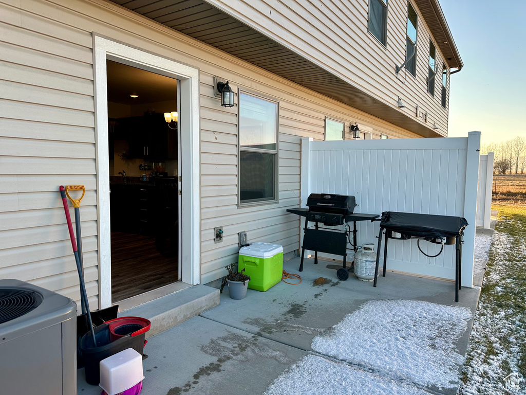 Patio terrace at dusk featuring central air condition unit and area for grilling