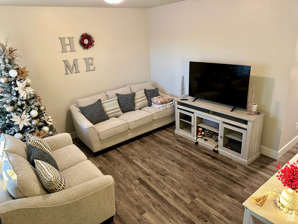 Living room featuring dark hardwood / wood-style flooring and lofted ceiling