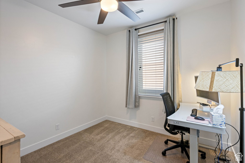 Carpeted office space featuring ceiling fan