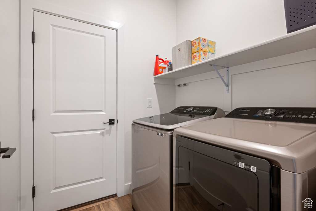 Laundry room with light hardwood / wood-style floors and washing machine and dryer