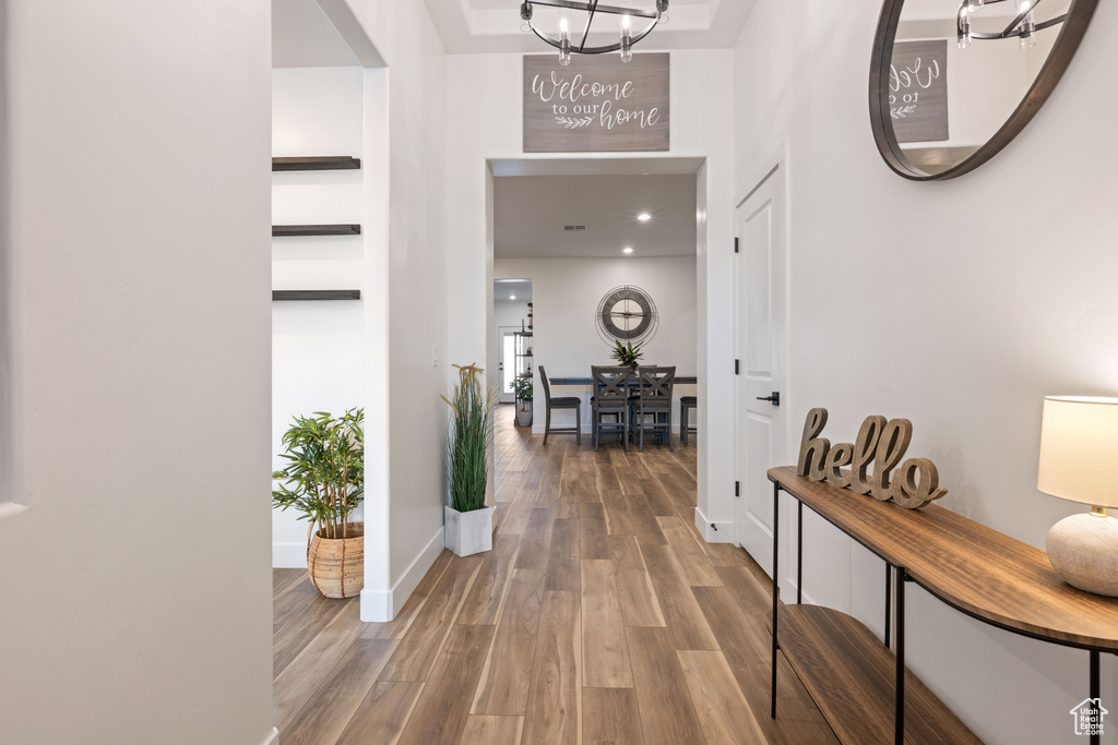 Hall featuring hardwood / wood-style flooring and a notable chandelier