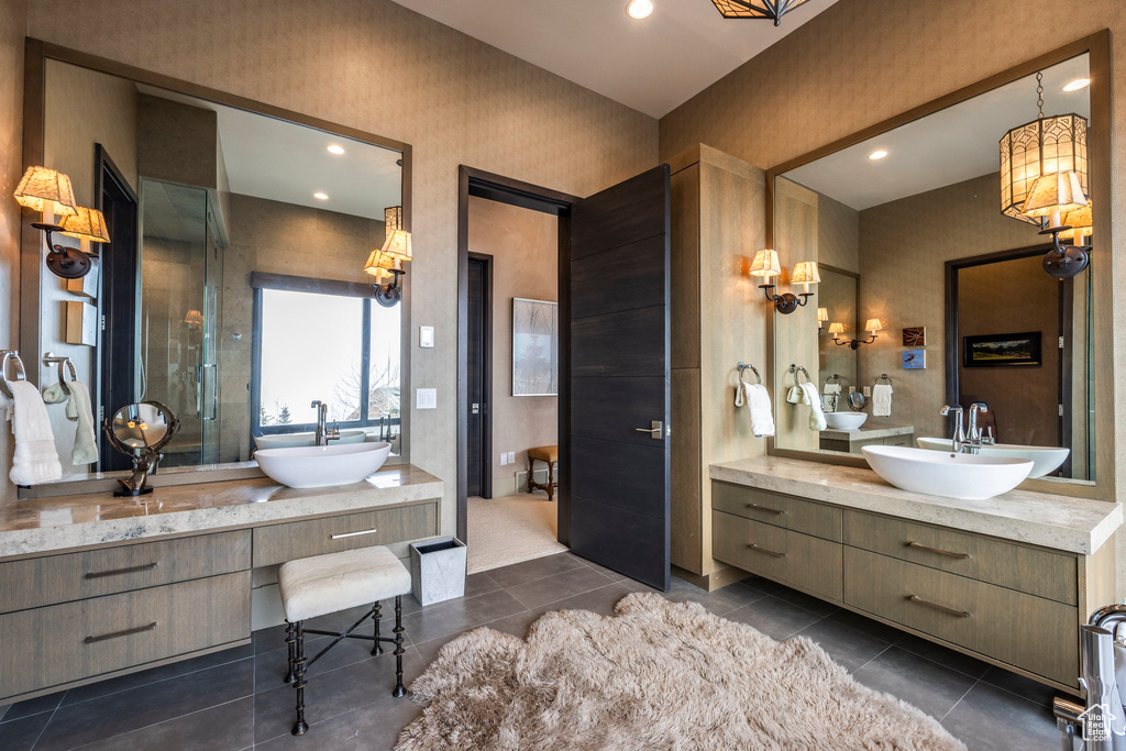 Bathroom featuring two vanities, tile patterned flooring, and recessed lighting