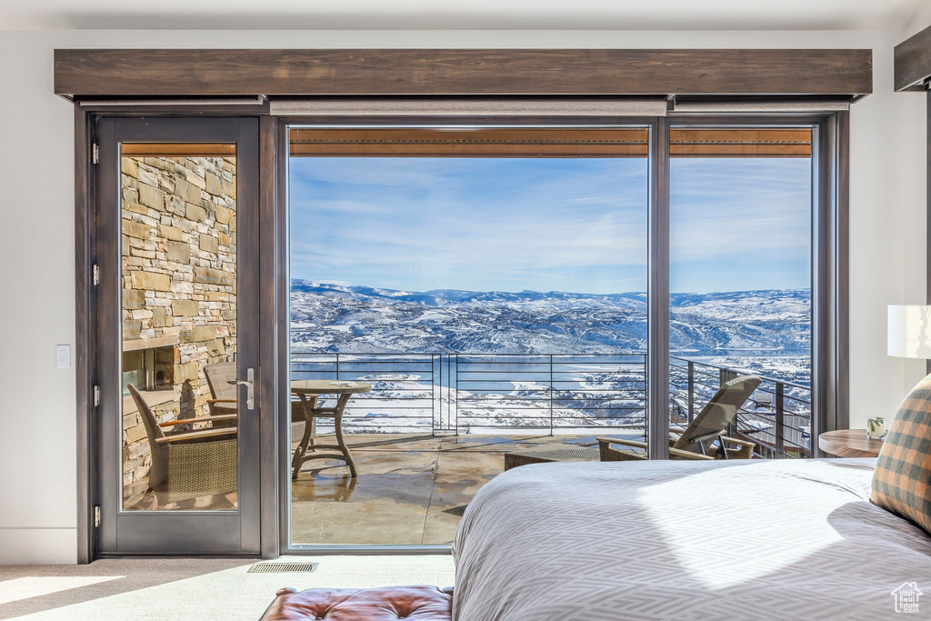 Bedroom featuring a mountain view, carpet, and access to exterior