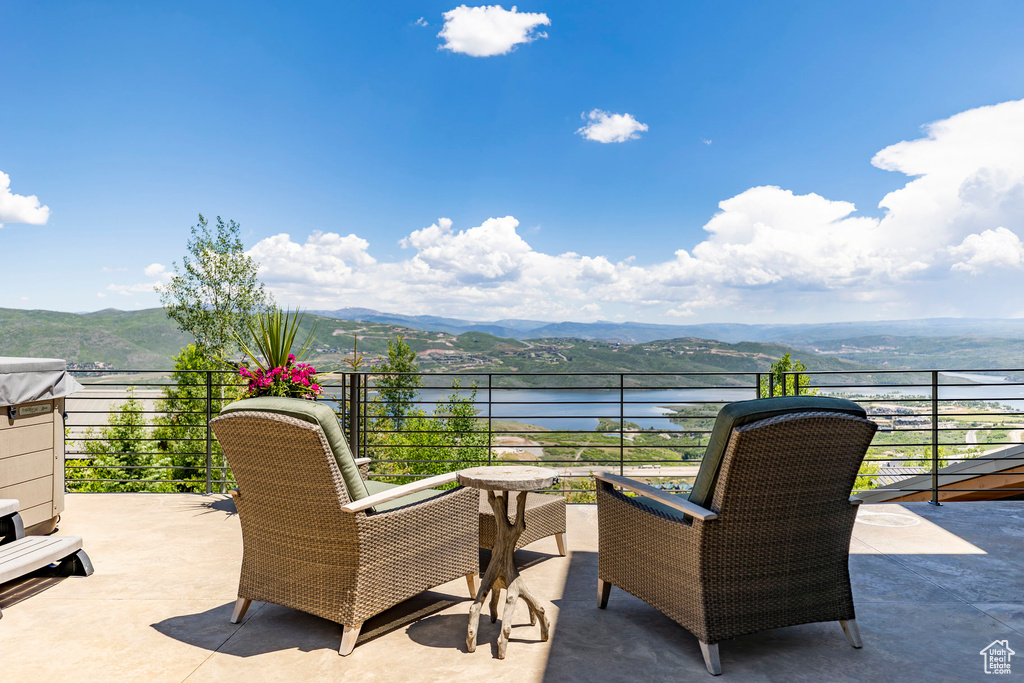 Patio / terrace featuring a water and mountain view