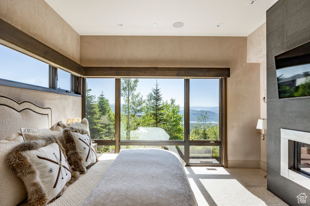 Bedroom featuring a fireplace, multiple windows, carpet flooring, and recessed lighting