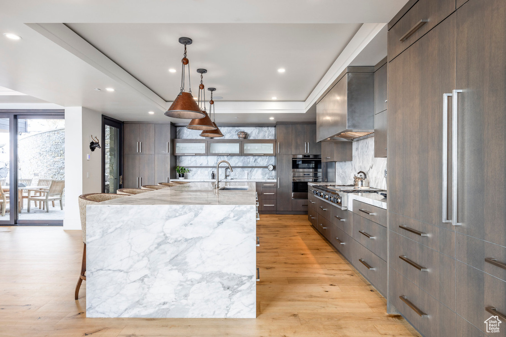 Kitchen featuring modern cabinets, a tray ceiling, open shelves, backsplash, and recessed lighting
