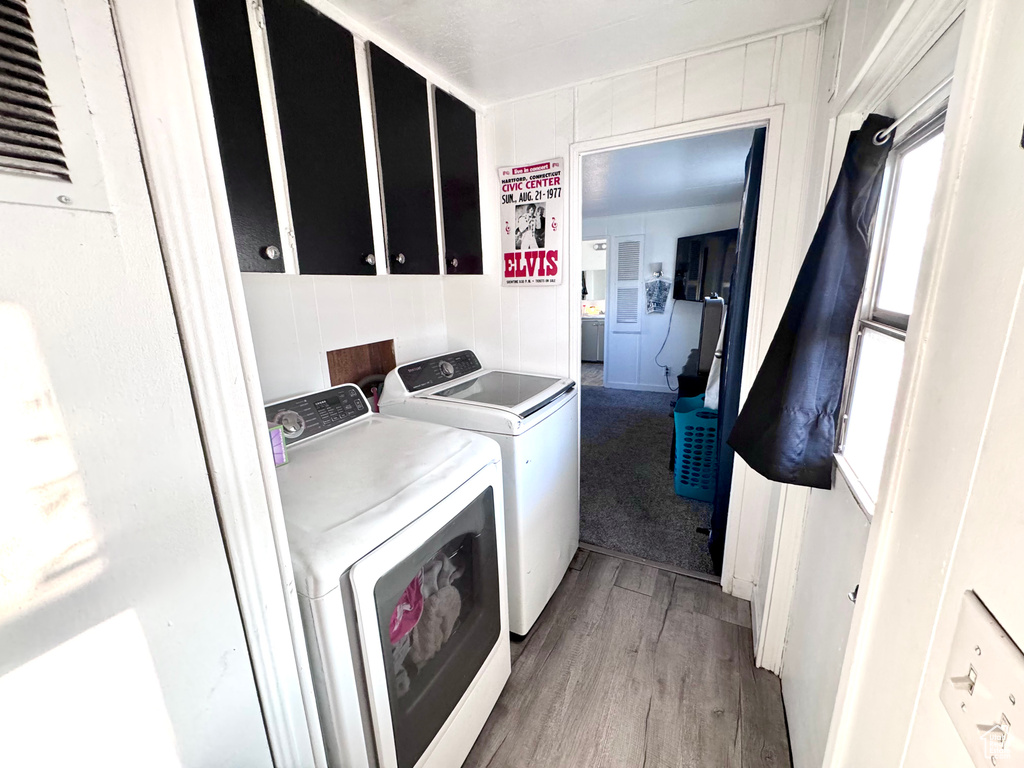 Laundry area with wood-type flooring and separate washer and dryer