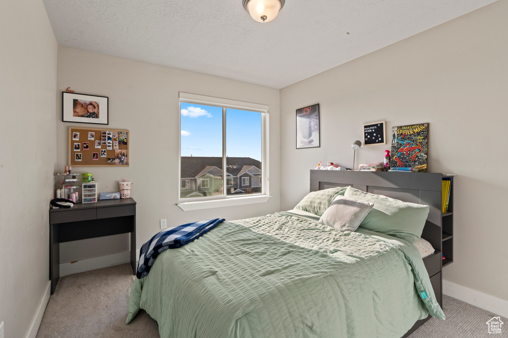 Bedroom featuring light carpet and a textured ceiling