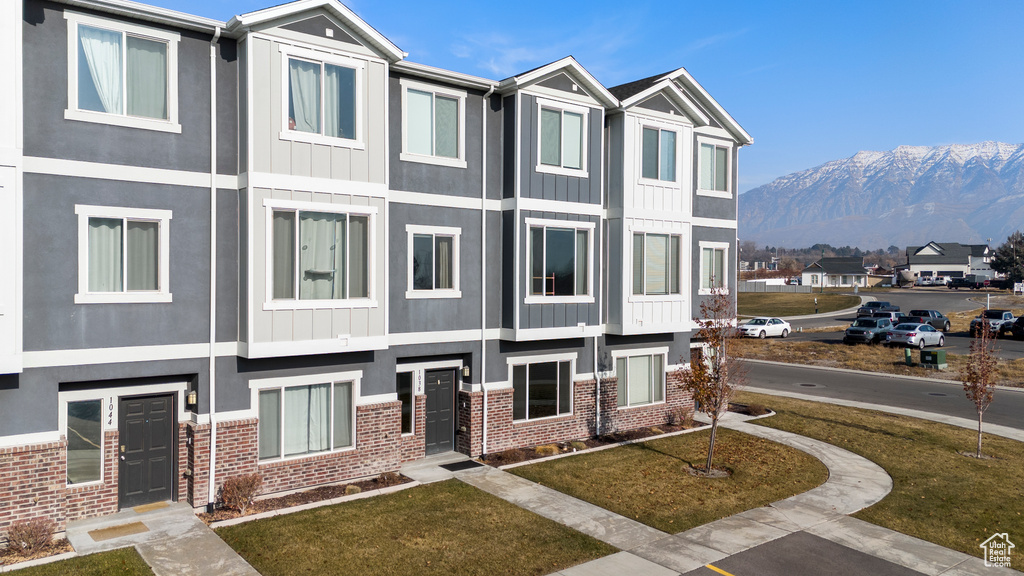 View of front of property featuring a mountain view and a front lawn