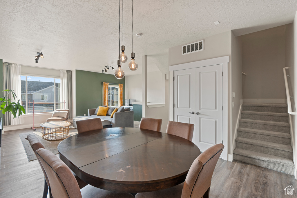 Dining room featuring light wood-type flooring and a textured ceiling