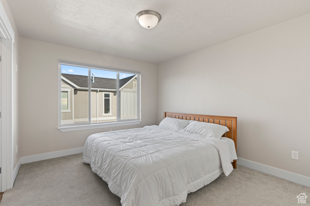 Carpeted bedroom with a textured ceiling