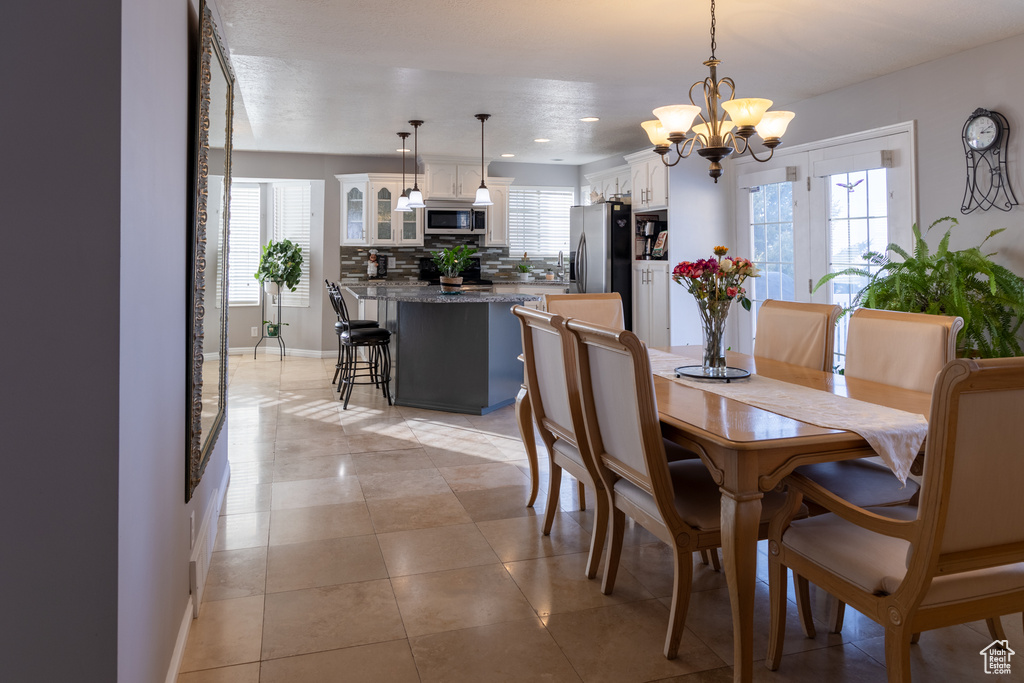 Dining space featuring a chandelier and light tile patterned floors