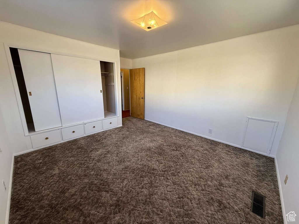 Unfurnished bedroom featuring carpet and a closet