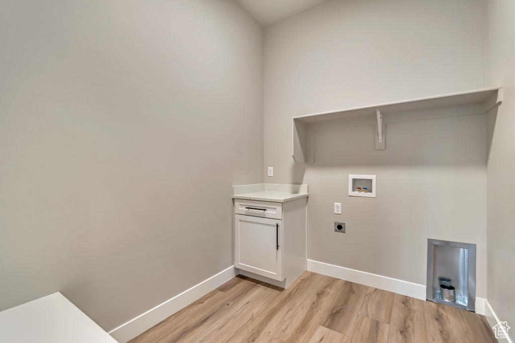 Clothes washing area with light wood-style floors, laundry area, electric dryer hookup, hookup for a washing machine, and baseboards